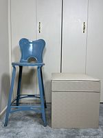 Blue metal stool and beige ottoman side by side for scale