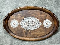 Top view of wooden oval tray with glass top and lace doilies