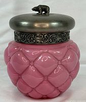 Front view of pink satin quilted biscuit jar with metal bear-finial lid