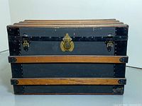 Front view showing black canvas, hardwood slats, brass lock and side latches