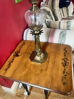 Full view of brass and glass lamp with shade on table