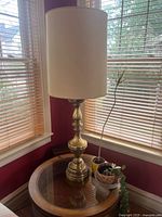 Full view of brass table lamp with beige shade