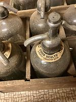 Close-up of neck label and siphon top on one bottle