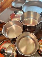Group shot of stainless pots, lids, non-stick pans and griddle