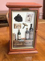Full view of wine-themed shadow box cabinet closed