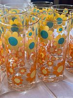 Group of sunflower pattern glass tumblers, close view of design