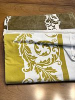 Two folded tablecloths showing both colourways