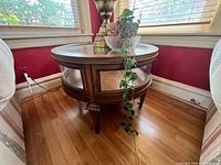 Round wood end table with glass top and glass side panels
