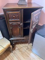 Front view cabinet closed showing carved panels and hardware