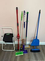 Photo showing full set of cleaning tools and step stool against wall on floor