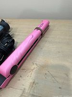 Close-up of pink Revlon hair straightener showing cord and clasp