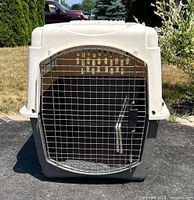 Front view of the extra large dog carrier with metal wire door closed, showing plastic body and latch mechanism.