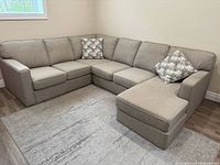 Full view of light gray sectional sofa under window with chaise on right