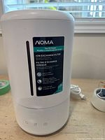 Front view of white Noma humidifier showing brand label and water level indicator.