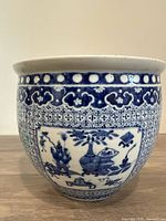 Front view of the blue and white porcelain planter showing the detailed Chinese motifs and patterns.