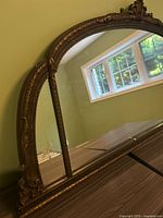 Side angle view showing wood frame with ornate details and side etched glass panel reflecting a window.
