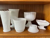 Full view of all six milk glass pieces showing variety of shapes and textures.