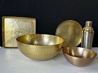 Front view of all 5 items on display: square and round trays, large and small bowls, and martini shaker.