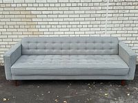 Front elevation of sofa against brick wall