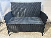 Front view of black resin wicker two seater loveseat for outdoor use, showing woven pattern and overall shape