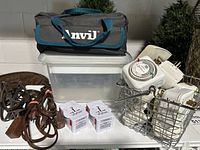 Photo showing Handy Anvil canvas tool bag on top of a clear plastic container, various extension cords, timer units, and white boxes arranged on white table.