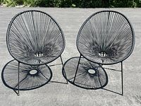 Two chairs side by side on asphalt surface, front view