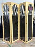 Full view of four cream lacquered panels with black latticework insets, showing lattice pattern and folding design.