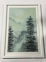 Full view of the framed winter landscape print depicting pine trees and mountains in cool tones.