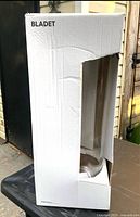 White IKEA box with cutout showing the clear glass floor vase inside, box labeled 'BLADET'.