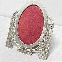 Full view of the antique style pewter photo frame with oval cutout and floral motifs.