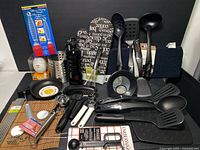 Overview of full lot including KitchenAid spatulas, pans, ice cream scoop, metal chopsticks, utensil holder, water bottle and other kitchen tools.