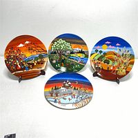 Four Poole Pottery transfer plates displayed on stands, showing collection of colorful seasonal and rural landscape scenes by Barbara Furstenhofer