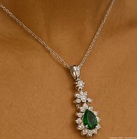 Pendant displayed on a light brown background showing the whole pendant on a black chain.