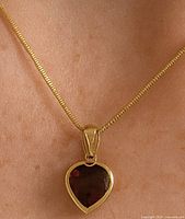 Pendant worn on chain, showing size and fit against the skin.