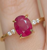 Close-up view of oval ruby center stone in four-prong setting