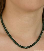 Necklace worn on model's neck showing drape, length, and bead color