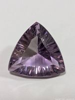 Top view of the purple faceted triangular trillion cut amethyst gemstone showing its color and internal inclusions.