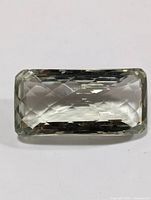 Top view of rectangular cushion cut green amethyst gemstone showing faceted surface and clarity.