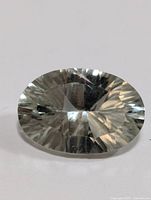 Oval faceted green amethyst gemstone showing top view with light green tint and faceting.