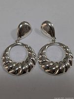 Front view of silver drop earrings showing teardrop studs and ribbed circular hoops