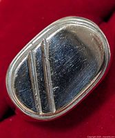 Close-up image of the sterling silver men's ring showing rectangular face with two raised parallel bars and surface scratches.