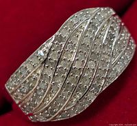 Close-up angled photo of the sterling silver ring with many small diamonds set in wave lines.