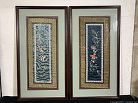 Pair of framed Chinese embroidered silk textile art pieces, hung side by side, showing overall condition and framing.