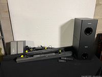 Black PHILIPS subwoofer and BOSE multimedia speakers with remotes and cables, showing full lot.
