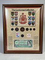 Framed Centennial Collection displaying coins, stamps, and one-dollar bill with Canadian Coat of Arms and provincial crests.