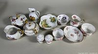Full set of Paragon, Limoges, Royal Albert chinaware with floral and gold trim details on display.