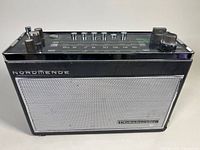 Front view of Normende Globetrotter radio with speaker grille and brand name visible.
