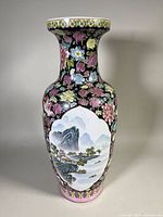 Front view of the vase showing floral dark background with a large landscape panel.