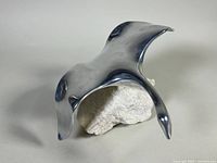 Top view of polished cast aluminum goose sculpture mounted on natural stone base showing sleek lines and surface reflections.