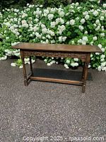 Full view of the solid oak sofa/console table showing its overall shape and medium brown finish with carved apron and legs.